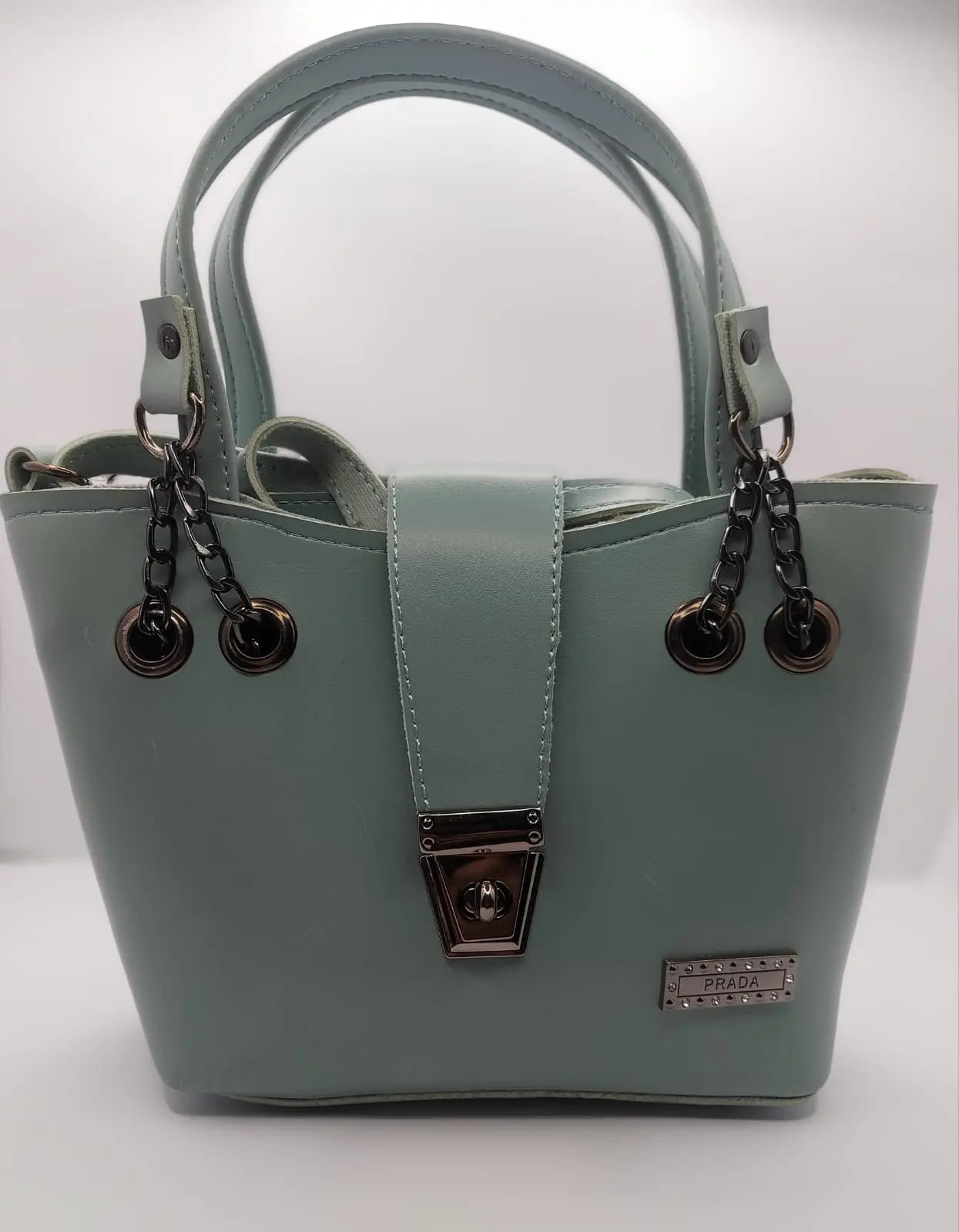 Mint Green tote bag with metallic twisted lock, crafted from premium PU leather. Features hand tote and adjustable shoulder straps, dual zippers for storage, and a sleek solid design with metallic details. Ideal for daily use or special occasions

