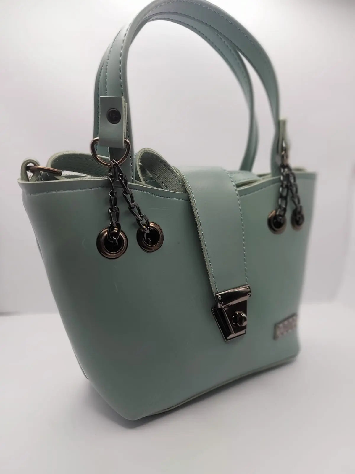 Mint Green tote bag with metallic twisted lock, crafted from premium PU leather. Features hand tote and adjustable shoulder straps, dual zippers fot storage, and a sleek solid design with metallic details. Ideal for daily use or special occasions